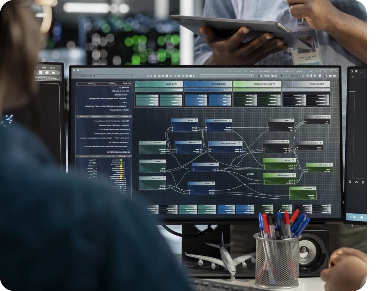 Engineer reviewing a node-based system diagram on a large monitor